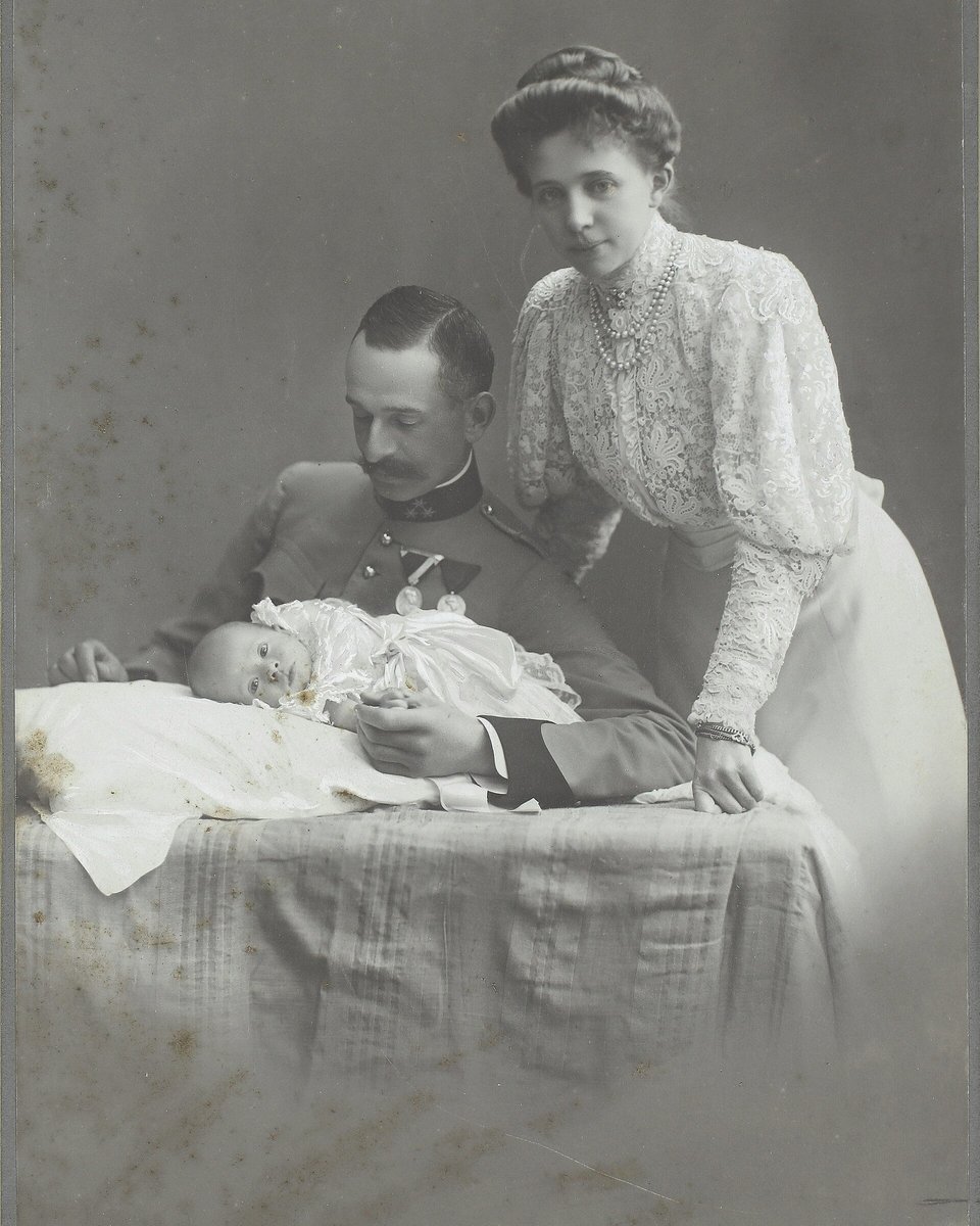 BEFORE: a black-and-white portrait of a soldier with his wife and baby, faded and with damp stains